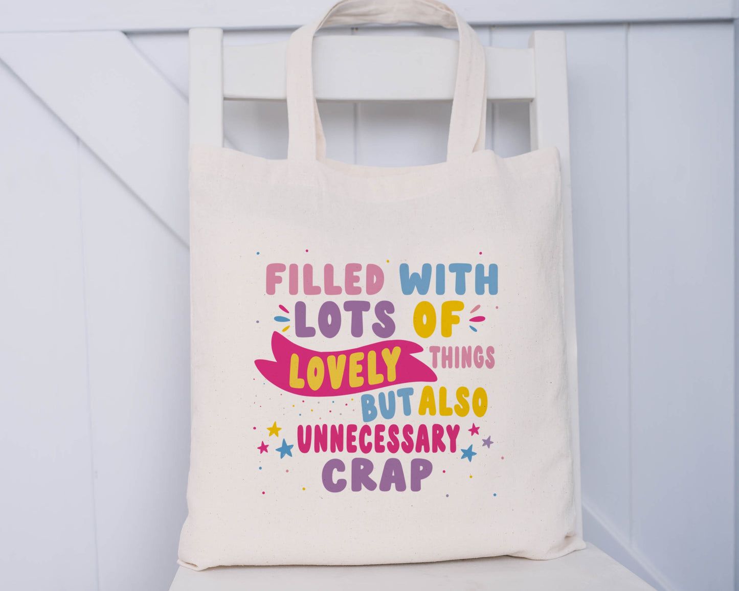 Natural Coloured Tote Bag, with the quote "Filled with Lots of Lovely Things but Also Unnecessary Crap" in pink, purple, blue and yellow writing