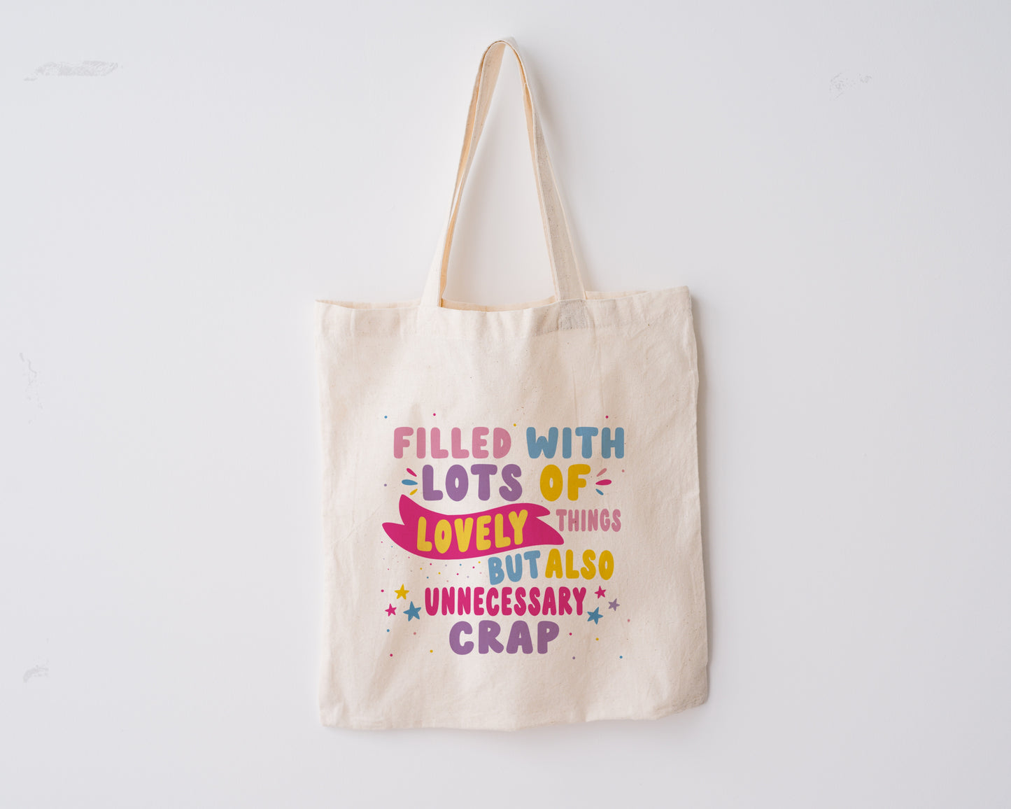 Tote Bag, with the quote "Filled with Lots of Lovely Things but Also Unnecessary Crap" in pink, purple, blue and yellow writing