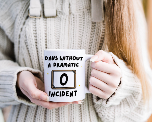 "Joyful person holding the 'Days Without a Dramatic Incident: 0' mug, showcasing fun design."