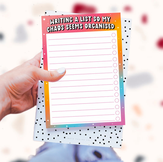  'Chaos to Organised' Notepad: A vibrant product image featuring the quote "writing a list so my chaos seems organised." The notepad is designed by Colourful Life, with an A5 size, tear-off sheets, and a sturdy cardboard backing.