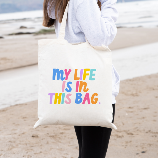 Tote bag including the phrase 'my life is in this bag' in colorful block lettering