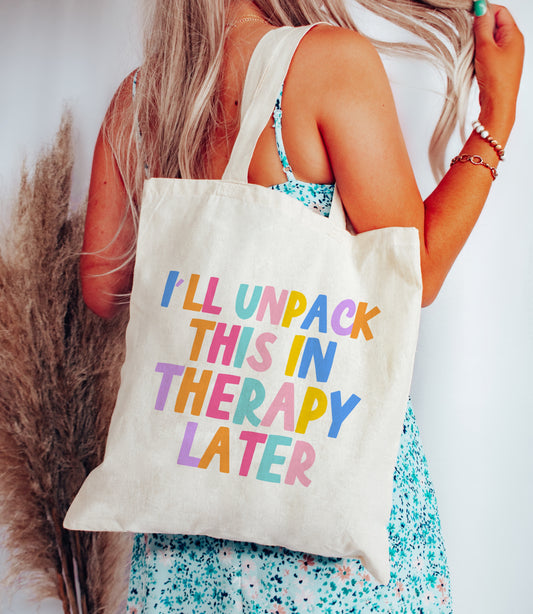"Tote Bag - 'Therapy Unpacker' design on natural cotton, showcasing the colorful quote 'I'll unpack this in therapy later.'"