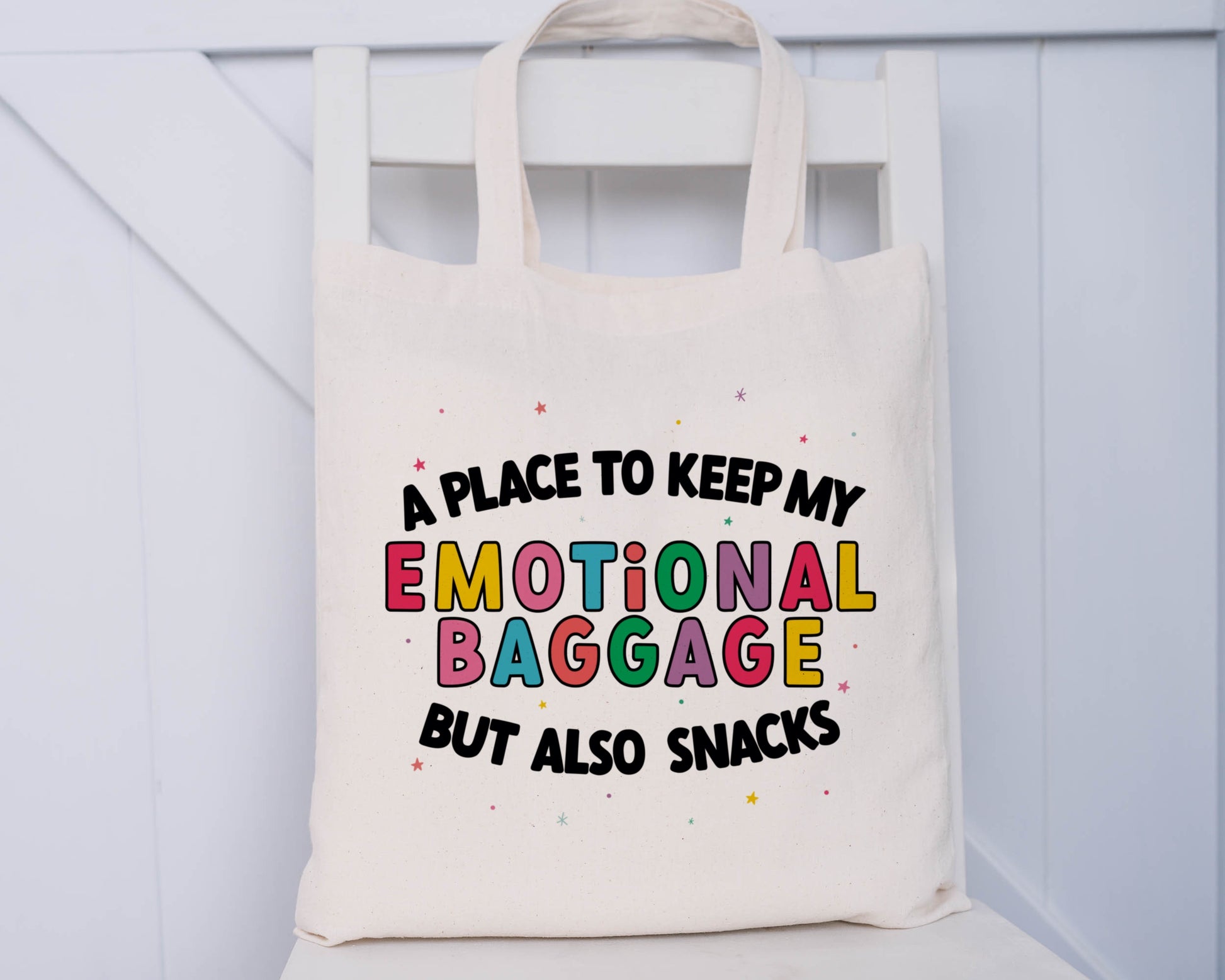 Natural coloured tote bag with the phrase 'a place to keep my emotional baggage but also snacks'