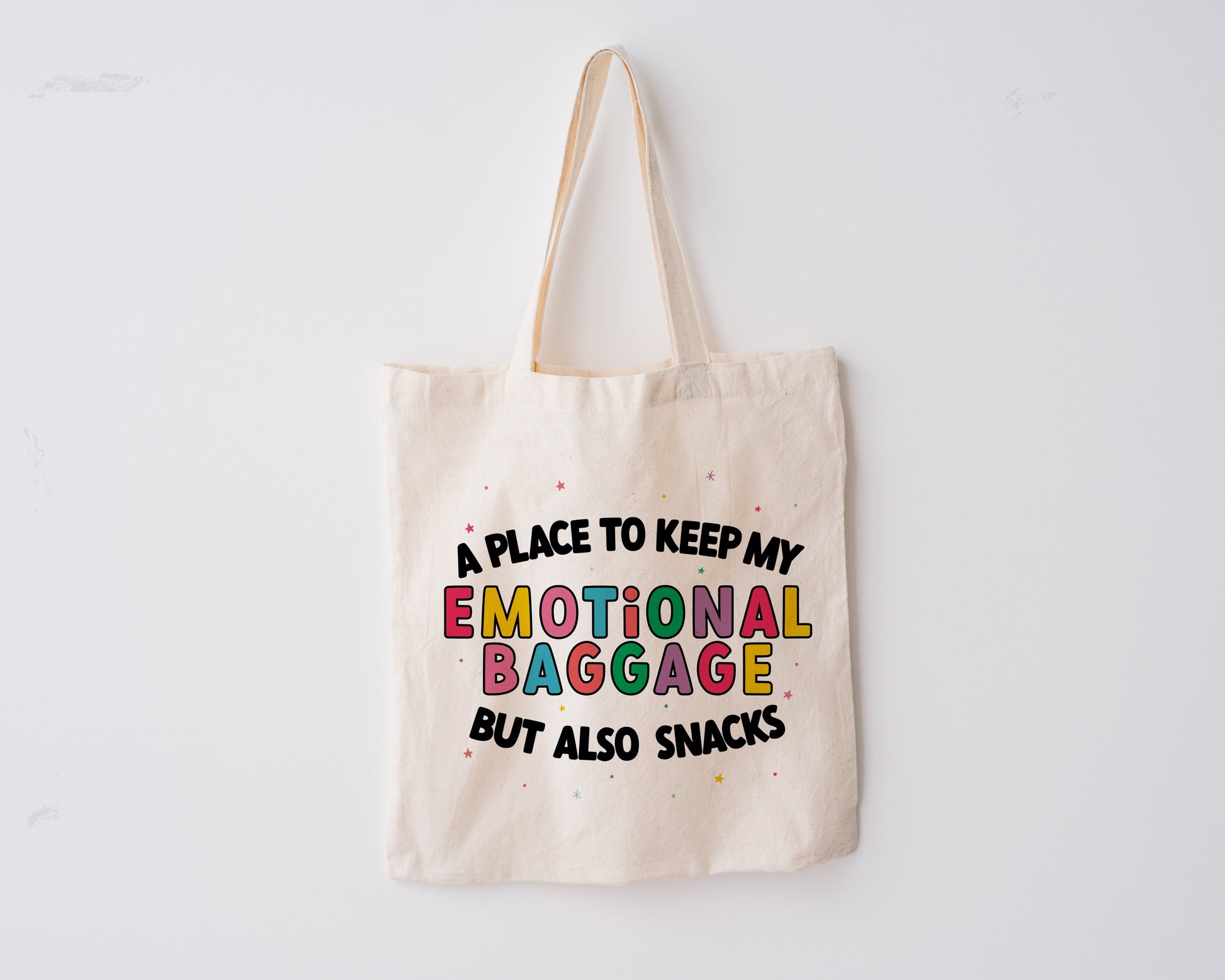 Natural coloured tote bag with the phrase 'a place to keep my emotional baggage but also snacks'